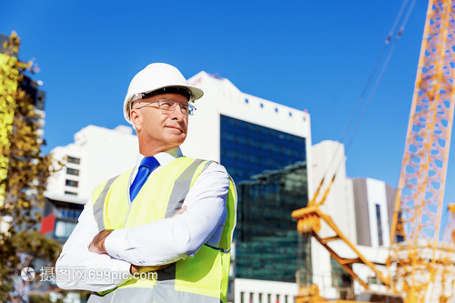 筑夢的剪影 建筑工地上穿安全背心的工程師與建設者